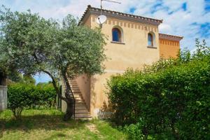 a building with a staircase next to a tree at Appartamento Residenziale Bilocale Citai San Teodoro in San Teodoro