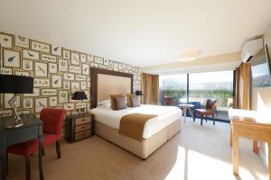 a hotel room with a bed and a desk and chairs at Park Farm Hotel in Norwich +159 photos