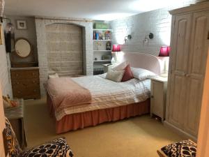 een slaapkamer met een bed en een bureau met een spiegel bij Cosy Cottage ground floor bedroom ensuite with private entrance in Chichester