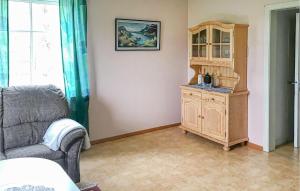 a living room with a wooden cabinet and a chair at Amazing Apartment In Boliden With Kitchen in Boliden