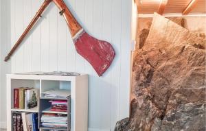 a largeaxe hanging from a wall next to a book shelf at Stunning Apartment In Arendal With Kitchen in Arendal