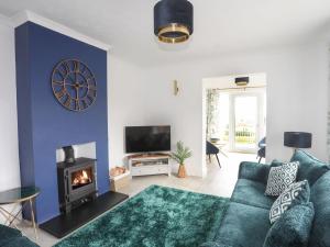 a living room with a couch and a fireplace at Awel Y Grug in Pwllheli