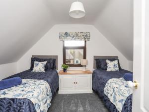 a bedroom with two beds and a window at Awel Y Grug in Pwllheli