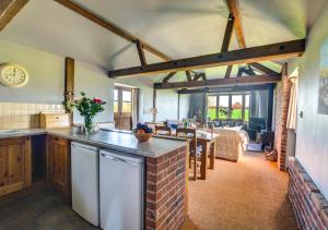 een keuken en een woonkamer met een aanrecht en een tafel bij Lilac Barn in Swanton Abbot