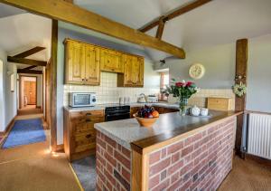 een keuken met houten kasten en een aanrecht bij Lilac Barn in Swanton Abbot