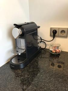 a black coffee maker on a counter with a bowl of fruit at Appartement Stuttgart Messe & Flughafen in Leinfelden-Echterdingen