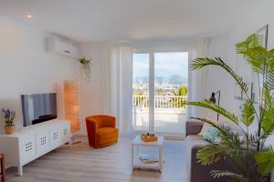 a living room with a couch and a tv at Veronica Beachfront Apartment by FESEAL in Port de Pollensa
