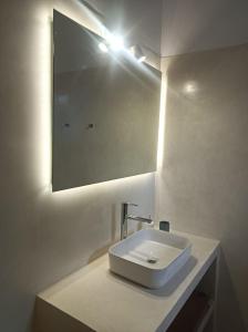 a bathroom with a white sink and a mirror at Kalymnos, très belle villa avec vue sur la mer in Kalymnos