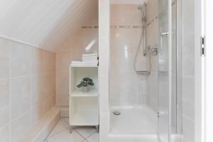 bagno bianco con doccia e servizi igienici di Yachthafenblick a Grömitz