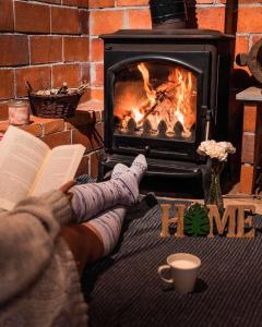 ラ・プラサにあるLa Congosta mágica aldea rodeada de montañasの暖炉前で本を読む者
