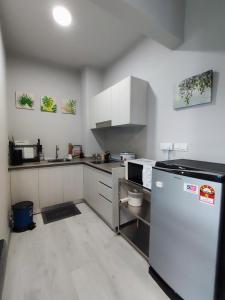 a kitchen with white cabinets and a refrigerator at SabahSuite@Jesselton Quay in Kota Kinabalu