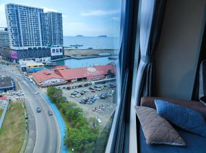 a view of a city from a window in a room at SabahSuite@Jesselton Quay in Kota Kinabalu