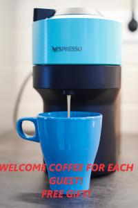 a coffee maker pouring coffee into a blue cup at Feel Home DeLuxe CORVIN # FREE PARKING # AC # Elevator in Budapest