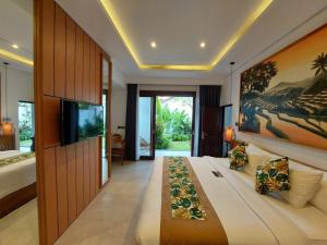 Alam Jepun Villa في ليغِيان: غرفة نوم بسرير كبير عليها لوحة كبيرة على الحائط