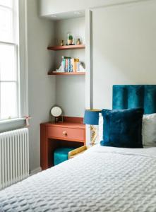 a bedroom with a bed and a blue headboard at Abbey Hideout - Lovely 1-Bed APT in Heart of Bath in Bath