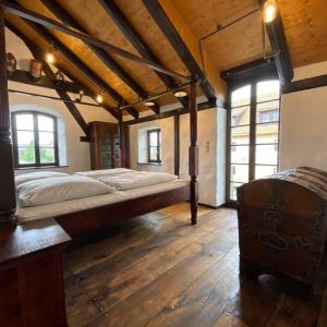ein Schlafzimmer mit einem großen Bett in einem Zimmer mit Holzböden in der Unterkunft Fewo WAFFENKAMMER für 7 Erw im Rittergut Leppersdorf in Wachau