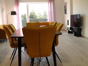 jadalnia ze stołem i żółtymi krzesłami w obiekcie Baltašiškės w Druskienikach