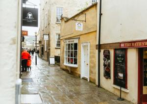 a cobblestone street with people walking down the street at Abbey Hideout - Lovely 1-Bed APT in Heart of Bath in Bath