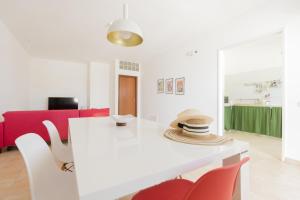 アルカモ・マリーナにあるVisitsicilia Bianca Mareの白いダイニングルーム(白いテーブル、赤い椅子付)