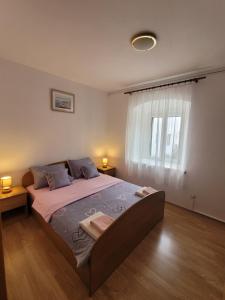 - une chambre avec un grand lit et une fenêtre dans l'établissement Malin Guesthouse, à Skradin