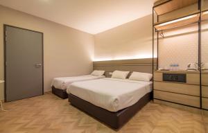 1 dormitorio con 2 camas y vestidor en Worldview Grand Hotel, en Kuala Lumpur