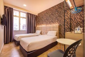 Habitación de hotel con 2 camas y mesa en Worldview Grand Hotel, en Kuala Lumpur