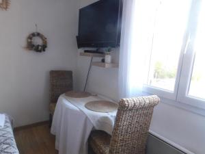 um quarto com uma mesa e duas cadeiras e uma televisão em Chez Marie em Régusse
