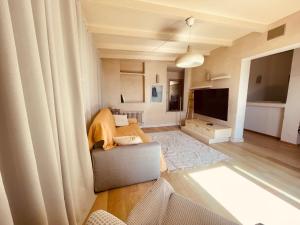 a living room with a couch and a television at Residence Conchiglia Aparthotel in Alassio