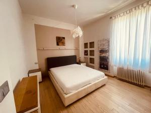 a bedroom with a white bed and a wooden floor at Residence Conchiglia Aparthotel in Alassio