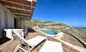 a patio with chairs and a swimming pool on a building at Villa Olimpo in Avola