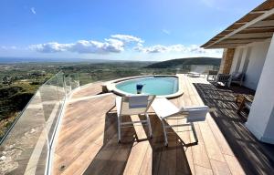 a deck with a swimming pool and two chairs at Villa Olimpo in Avola
