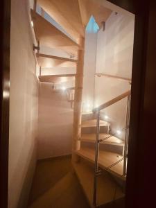 una escalera en una habitación con estanterías de madera en Residence Conchiglia Aparthotel, en Alassio