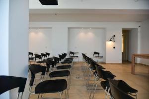 a room with a bunch of chairs and a white wall at Lena Mare Boutique Hotel in Acharavi