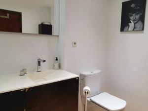 een witte badkamer met een wastafel en een toilet bij Alojamiento Cortes de Aragón, centro Jaca, wifi in Jaca