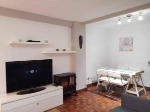 een woonkamer met een flatscreen-tv en een tafel bij Alojamiento Cortes de Aragón, centro Jaca, wifi in Jaca