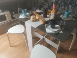 Villefranche-Sur-Cher的住宿－Agréable chambre d’hôte à la campagne，一张桌子,两把椅子,一张桌子,上面有食物