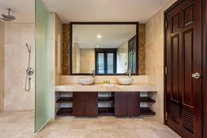 uma casa de banho com 2 lavatórios e um espelho em Elegant Pool Villa In 5star Resort My Khe Beach em Da Nang