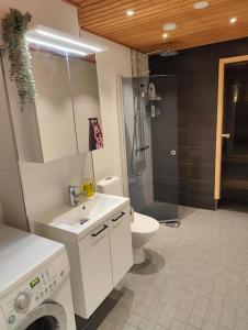 a bathroom with a sink and a toilet and a shower at Parvekkeellinen ja saunallinen kaksio Hyvinkäällä in Hyvinkää