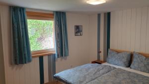 1 dormitorio con cama y ventana en Apartment Sonnenbüchel en Wald am Arlberg