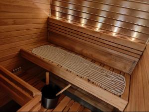 a bench in a sauna with a bucket in it at Parvekkeellinen ja saunallinen kaksio Hyvinkäällä in Hyvinkää