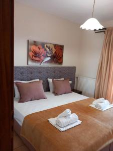 a bedroom with a bed with two towels on it at Pansion Fani in Ouranoupoli