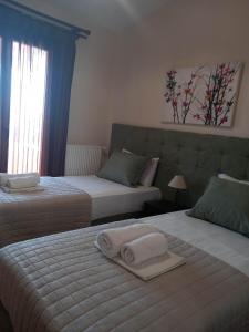 a hotel room with two beds with towels on them at Pansion Fani in Ouranoupoli