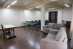 a living room with a couch and a table and chairs at Hotel Colina Verde in Concordia