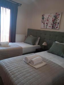 a bedroom with two beds with towels on them at Pansion Fani in Ouranoupoli