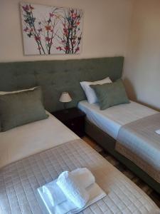 una camera con 2 letti e un asciugamano sul letto di Pansion Fani a Ouranoupoli