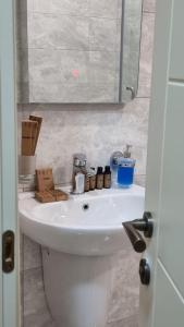 een badkamer met een witte wastafel met dozen erop bij GG ApartHotel in Batoemi