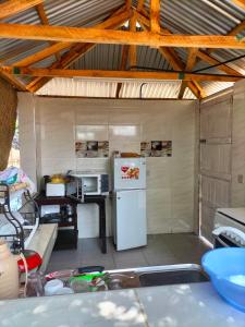 a kitchen with a white refrigerator and a table at Kikambala Eco Villas in Mombasa
