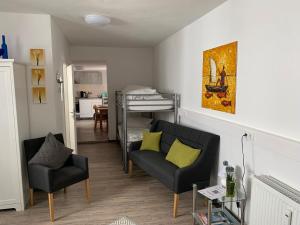 Hostel am Ostentor في ريغنسبورغ: غرفة معيشة مع أريكة وسرير بطابقين