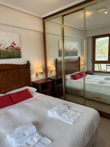 Cette chambre comprend 2 lits et un miroir. dans l'établissement Bakio, magnificas vistas a la mar, à Bakio
