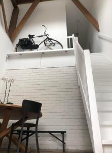 uma bicicleta sentada numa prateleira acima de uma escada em Rustig logeerverblijf aan de rand van de stad em Lekkum